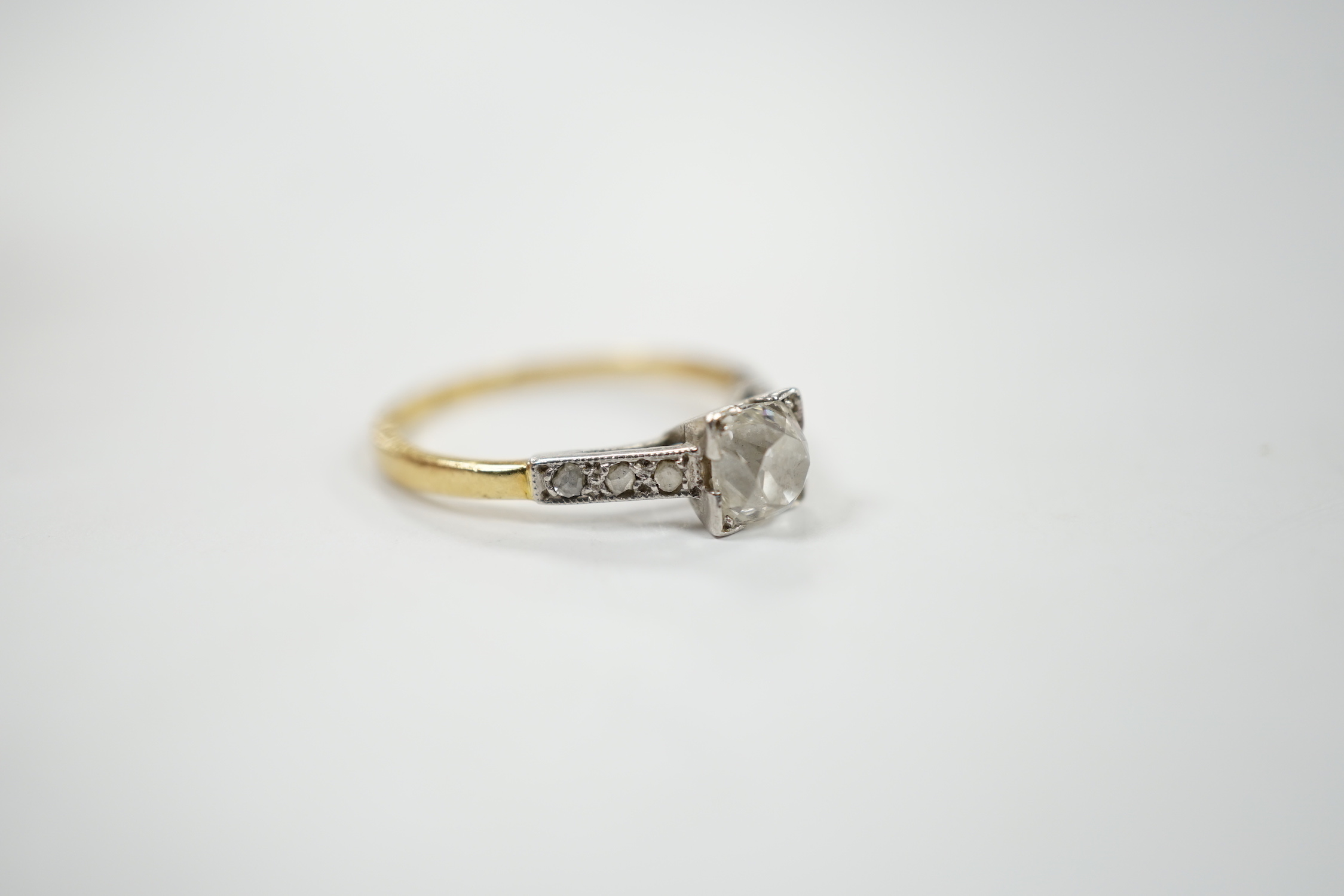A 1920's yellow metal and single stone old mine cut diamond set ring, with six stone diamond set shoulders, size K/L, gross weight 2.2 grams.